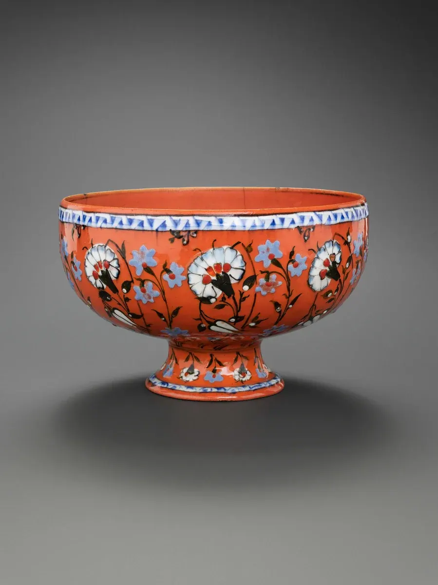 Iznik bowl with a coral ground and carnation and tulip sprays, Turkey, about 1560 to 1575