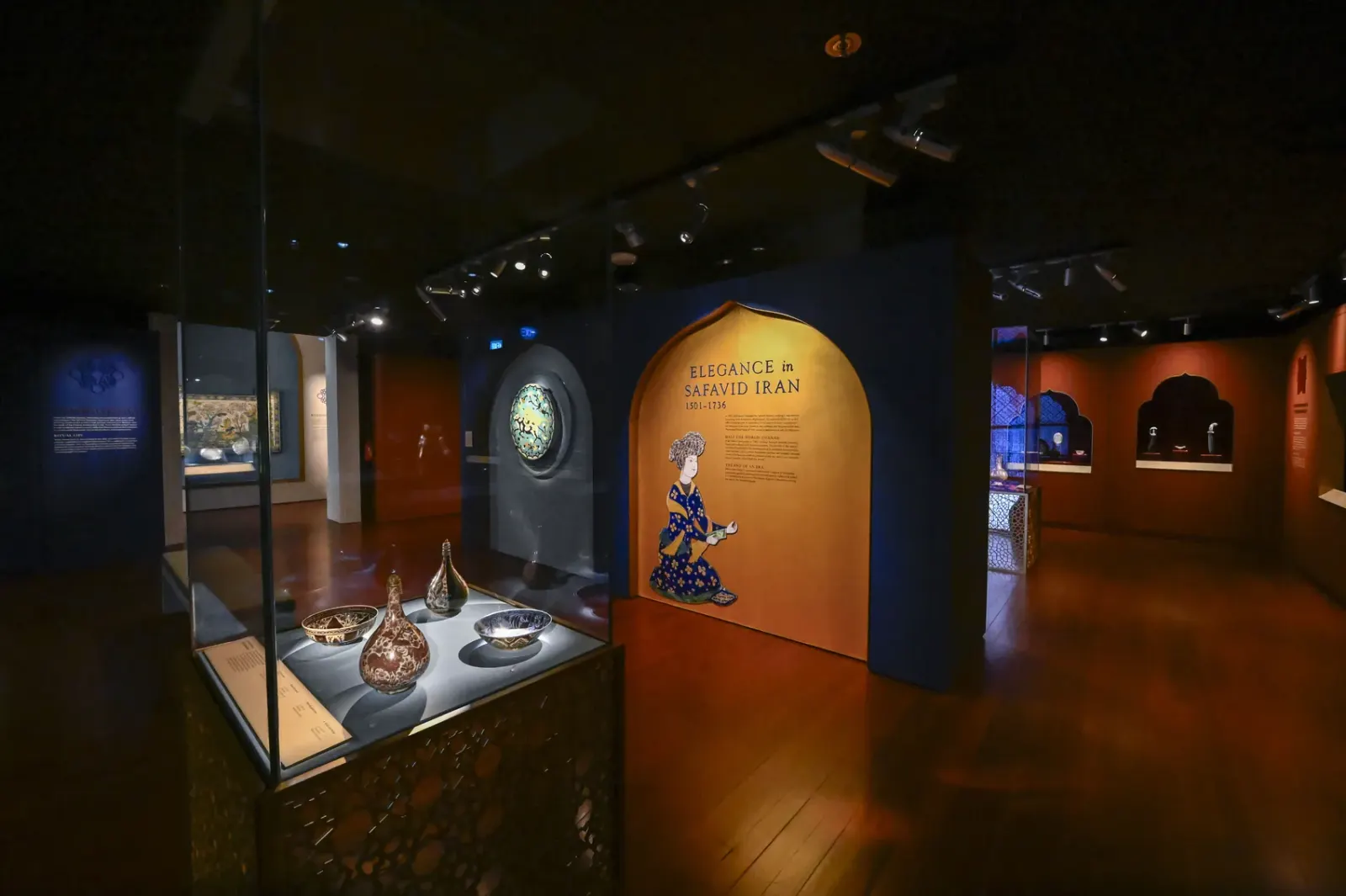 The Elegance in Safavid Iran gallery: a cobalt blue wall with a gold arched title panel