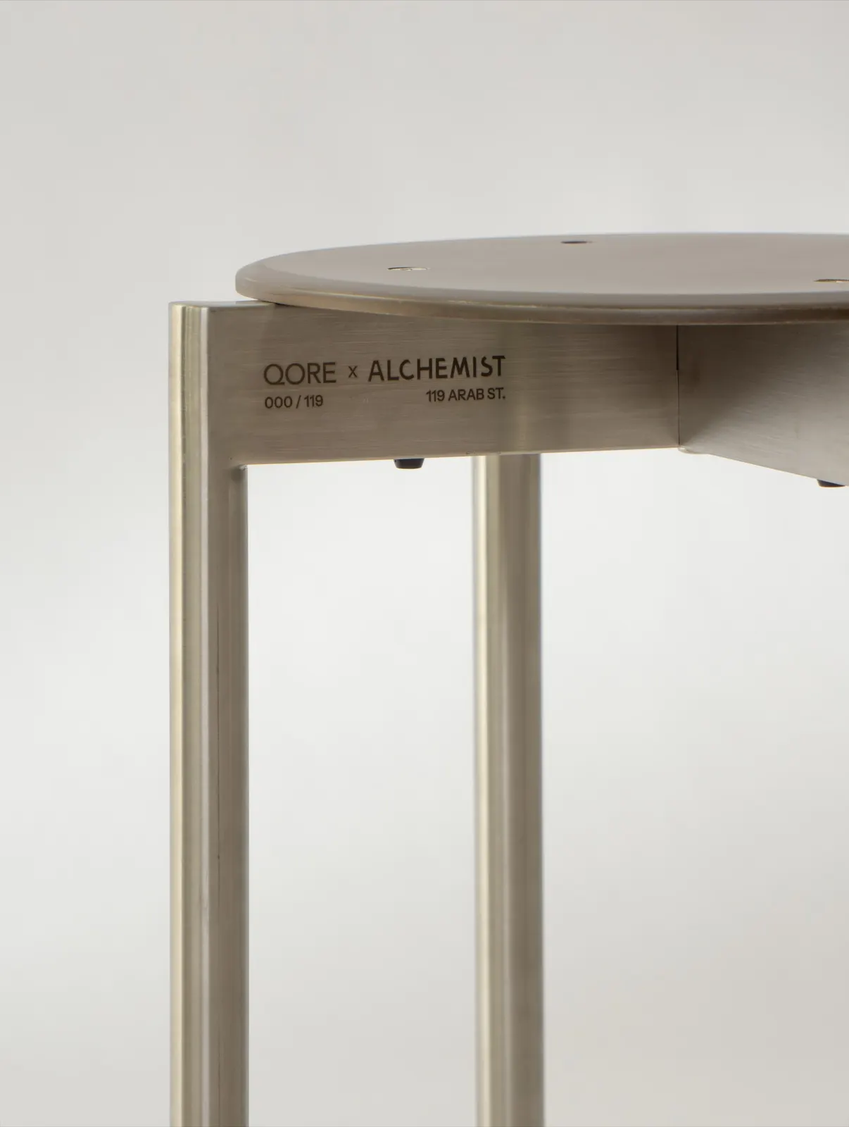 The QORE × Alchemist engraving and edition number on a Betterism Stool