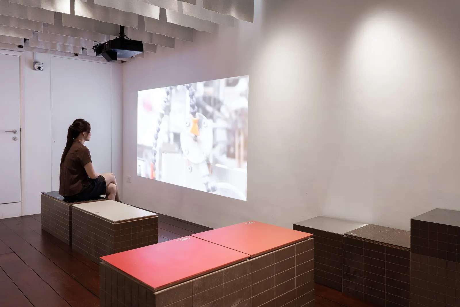 A visitor watching a film of QORE's process on Level 3